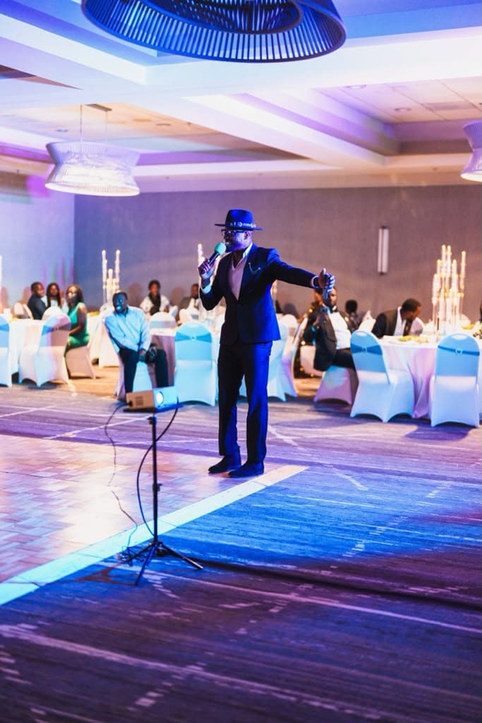 Host at the mic, evening composed around him.