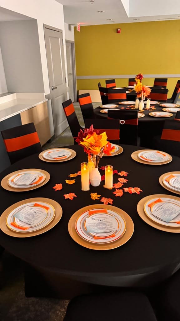 Intimate dinner table with low candles, white linens, and careful place settings.